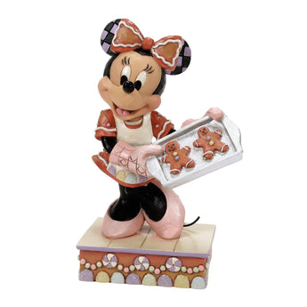 Minnie Mouse figurine holding a tray of gingerbread cookies on a white background