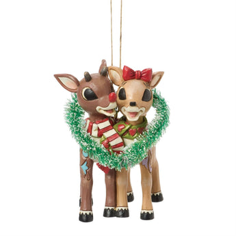 Jim Shore Rudolph Traditions ornament featuring Rudolph and Clarice inside a sisal heart wreath with entwined scarves and hand-painted folk-art details.
