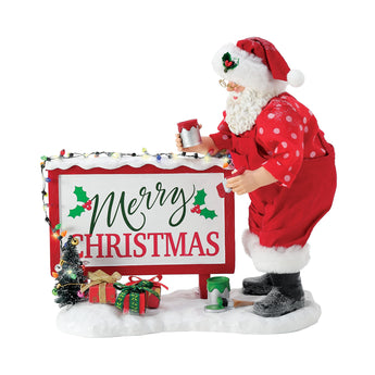 Possible Dreams North Pole Greeting Santa figurine painting a lighted Merry Christmas billboard with LED lights and Clothtique fabric details.