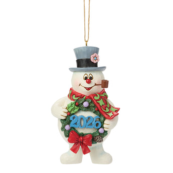 Jim Shore Heartwood Creek Frosty the Snowman ornament holding a festive wreath with 2026, featuring hand-painted folk-art details, holly accents, and a red holiday scarf.