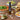Olivelle caramelized garlic oil bottle on a table with pizza, salad, and bread