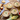Bowls of corn chowder on a wooden table with bread and corn ears.