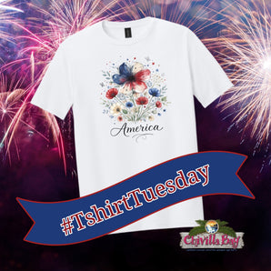 White t-shirt with floral design and 'America' text against a fireworks background, featuring '#TshirtTuesday' and Chivilla Bay logo.