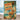 A rectangular metal sign with rounded corners featuring a retro pin-up beach illustration. The sign shows a woman in a tropical bikini standing near a palm tree and ocean, with a large sign reading “Beware of Falling Coconuts.