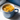 Blue mug filled with soup on a light surface