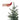 Hand holding a red cardinal ornament near a small green Christmas tree.