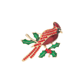 Decorative brooch with a red bird and green holly leaves on a white background