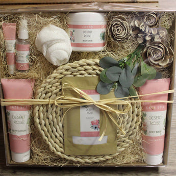 Desert Rose Gift set with rose-scented products including body lotion, cream, and bath bombs in a decorative box.