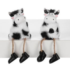 Black and white fluffy cow shelf sitter figurines with soft fur accents available in two poses by Ganz Gift.