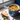 Blue mug of soup with a spoon and a sandwich on a windowsill
