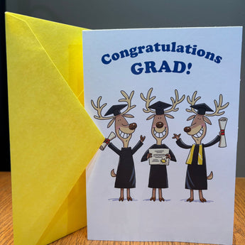 Graduation card with cartoon deer wearing graduation caps and gowns, featuring a yellow envelope.