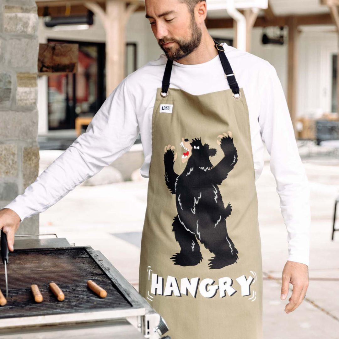 Hangry Bear BBQ Apron in sage green with a hangry-looking bear design, adjustable neck strap, and black trim.