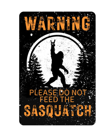 Black tin sign with orange text readying "Warning: Please Do Not Feed the Sasquatch" - funny camping or Bigfoot-themed decor