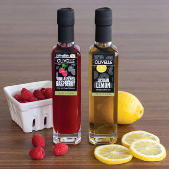 Berry Bright Better Together Gift Set with Sicilian Lemon Infused Olive Oil and Vine-Ripened Raspberry White Barrel Aged Balsamic with fruit on table top.