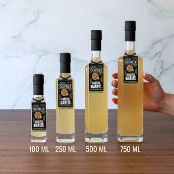 Set of Olvelle roasted garlic oil bottles in various sizes on a marble background