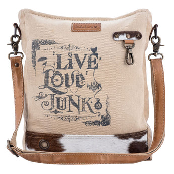 Canvas crossbody bag with 'Live Love Junk' text and cowhide accents on a white background