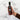 A hand holds a bottle of Olivelle Vine-Aged Raspberry Non-Alcoholic Salad Dressing against a white marble background, surrounded by text callouts highlighting product benefits like no added sugars, no artificial flavors, made from real grapes, and naturally sweet and thick.