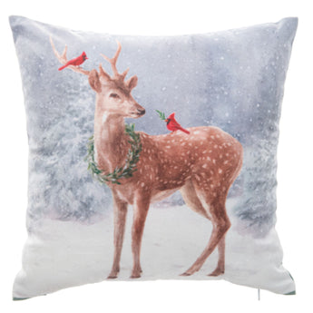 Decorative pillow with a deer and cardinal design on a snowy background