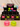 A retail display of squeeze toys in black boxes labeled 'squeeze toys' and 'Ages 6+', with two large translucent apple-shaped toys in front: one pink and one lime green. Background shows a soft beige curtain and more colorful plush bears and gift boxes on a shelf.