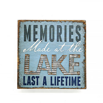 Decorative sign with text 'Memories Made at the Lake Last a Lifetime' on a light blue background.