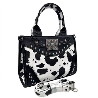 Black and white cow print handbag with decorative elements on a white background