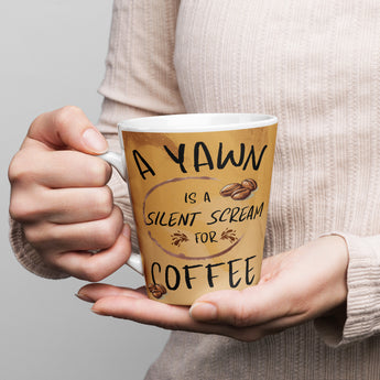 12 oz tan ceramic latte mug with the phrase "A Yawn is a Silent Scream for Coffee" and coffee bean graphics.