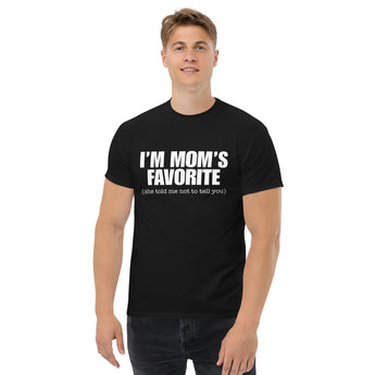 Man wearing a black t-shirt with the text "I'm Mom's Favorite (she told me not to tell you)" Funny Graphic in white.