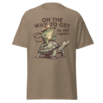 Funny frog riding tortoise “On the Way to Get My Sh*t Together” western graphic unisex cotton t-shirt.