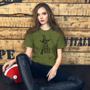 Funny witch t-shirt - "Yes, I Can Drive a Stick" graphic tee with broom and witch hat on Olive colored tee.