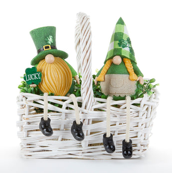 Two decorative gnomes with green hats and black boots in a white woven basket on a white background.