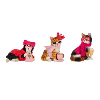 Assortment of cat-themed products including figurines, t-shirts, socks, lounge pants, stuffed animals, ornaments, slippers, and towels from Chivilla Bay's Cat Lovers Collection.
