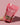 Hand holding a pink package of 'Sweetheart Crunch Granola' by LL's Kitchen against a pink background