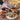 Person pouring Harvest Fig Balsamic over a salad with charcuterie board in the background