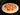 pizza being sliced directly on baking tray