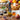 Blood Orange Infused Olive Oil Bottle with fruits, salads, desserts and pancakes in background.