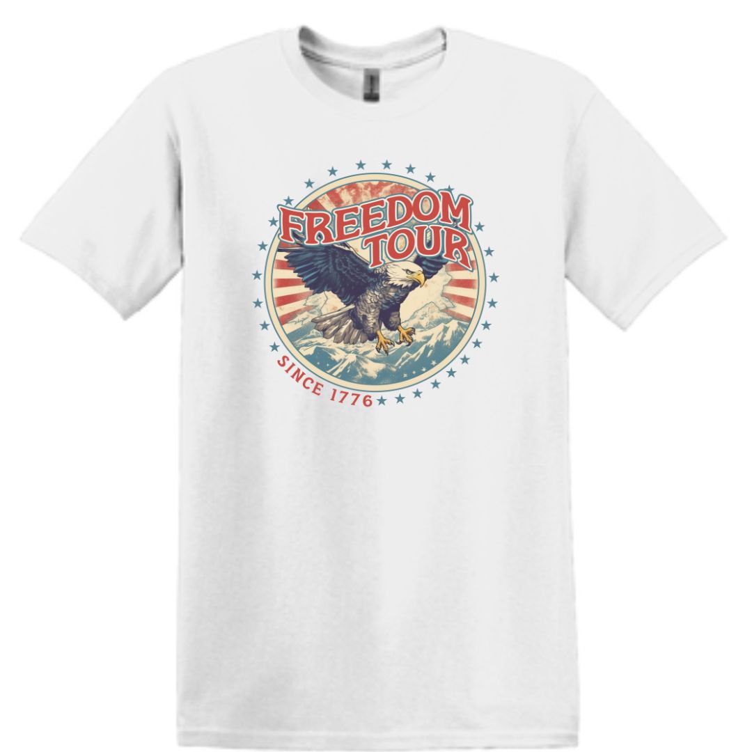 T-shirt featuring a vintage "Freedom Tour" design with red, white, and blue colors, depicting mountains and an American Eagle in flight, symbolizing freedom and the American spirit.