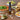 Olivelle caramelized garlic oil bottle on a table with pizza, salad, and bread.