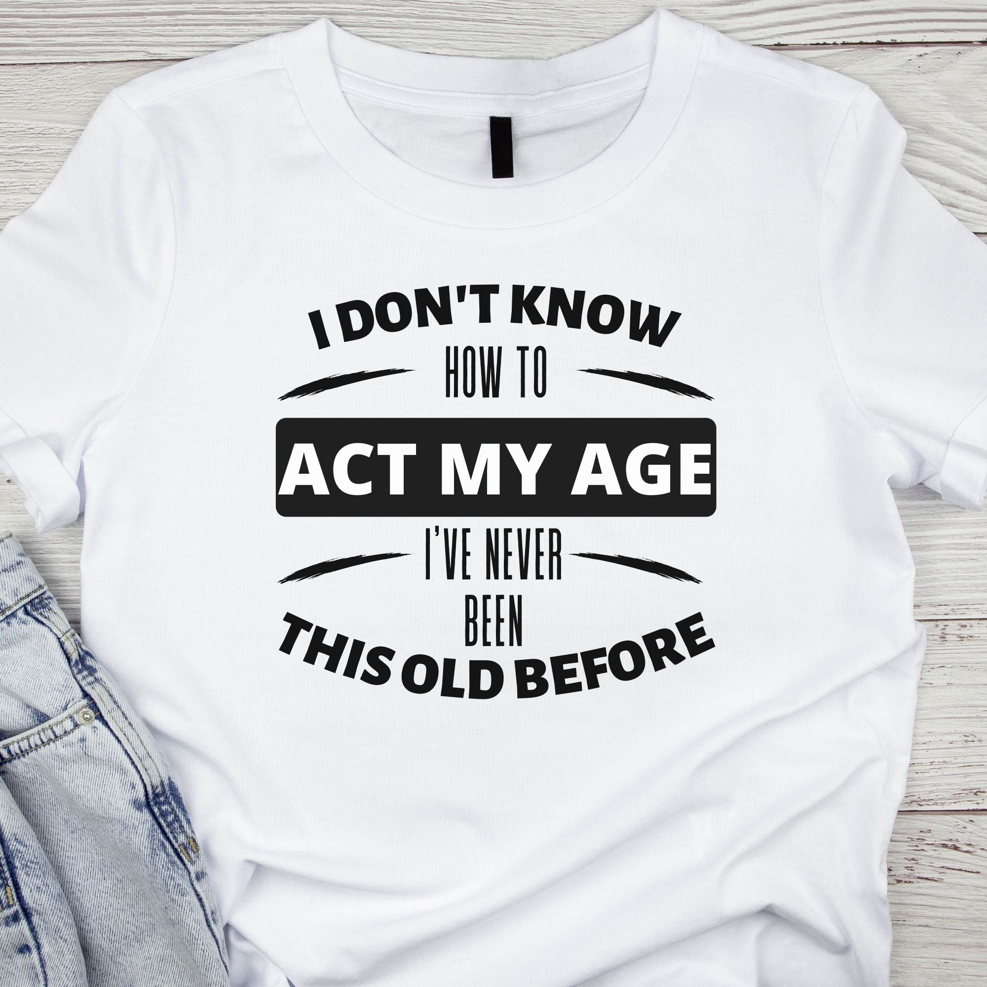 Funny Graphic Tee with "I don't know how to act my age, I've never been this old before" design on front of white cotton tshirt.