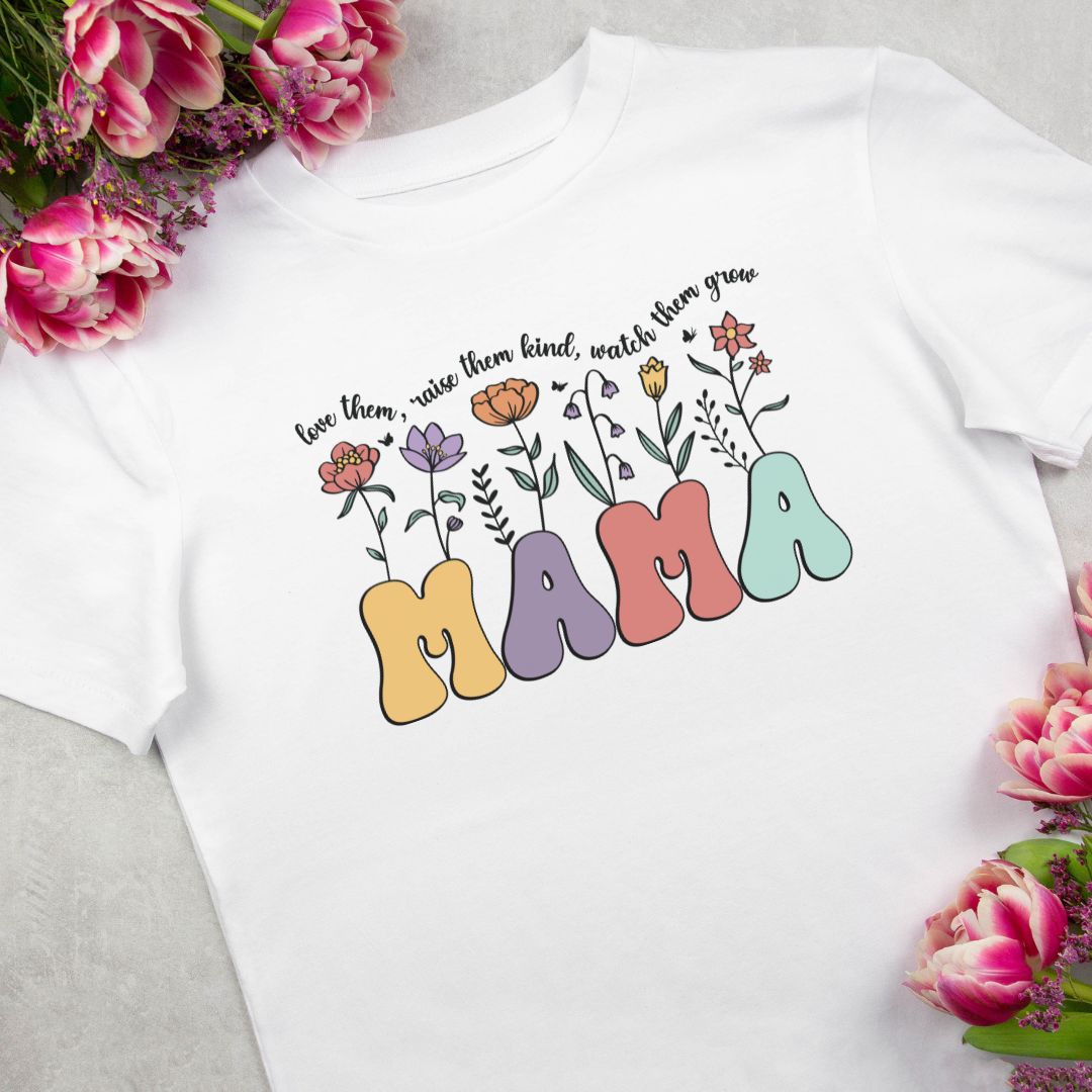 White Cotton Tee with Mama Wildflower Retro design with the quote 'Love them, raise them kind, watch them grow', available in sizes Small to 3XL. Lifestyle Mockup
