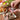 Person seasoning food with mediterranean rosemary on a wooden table with bread and vegetables.