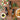 Three bottles of Olvelle olive oil on a wooden table with food items and olive branches.