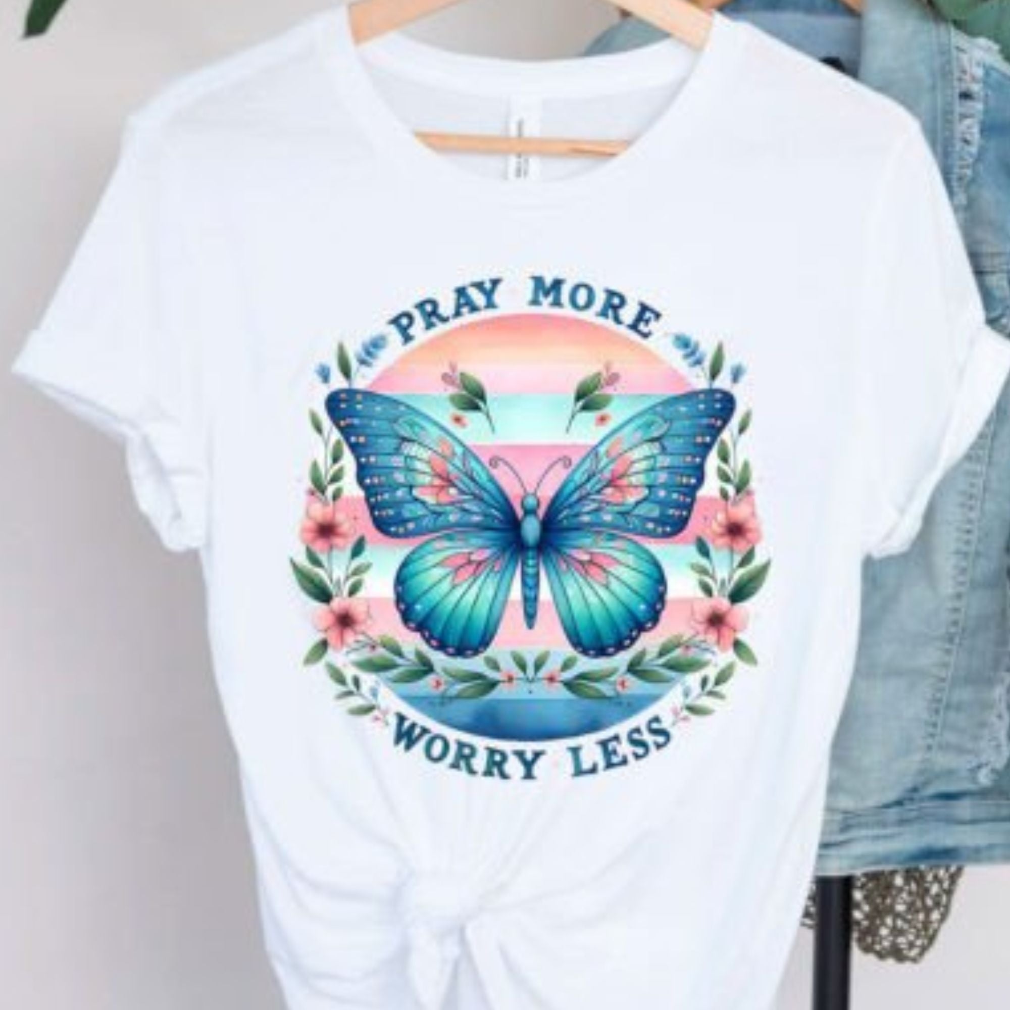 White cotton 'Pray more, worry less' graphic t-shirt with a beautiful butterfly and floral design, symbolizing tranquility and faith, available at Chivilla Bay.
