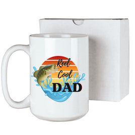 White 15 oz ceramic coffee mug with 'Reel Cool Dad' text and a colorful watercolor fish design, ideal for dads who love fishing. Comes with gift box.