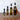 Set of four roasted shallot olive oil bottles with varying capacities on a wooden surface.