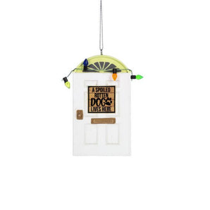 Miniature white front door ornament with colorful holiday lights and a sign that reads "A Spoiled Rotten Dog Lives Here."