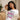 Woman wearing a funny white t-shirt with humorous text, sitting on a couch.