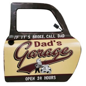 Decorative garage door with 'Dad's Garage' text and humorous quote on a white background