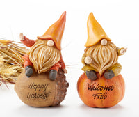Fall Gnome Figurines with an orange gnome on top of an acorn with "Happy Harvest" engraved on it and a gnome dressed in yellow on top of a pumpkin with welcome fall engraved on it. 