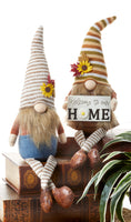 Festive Fall Fabrics Gnomes with fabric dangle legs that lets them easily sit on a bookshelf or tiered tray. Choose from either Denim Fabric Gnome or the Gnome holding the "Welcome to our Home" Sign