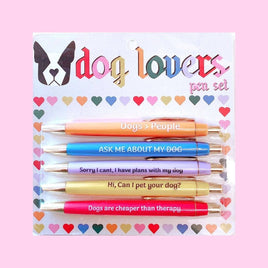 The Dog Lovers Pen Set includes five pens with funny sayings dedicated to dogs, such as 'Dogs are cheaper than therapy' and 'Ask me about my dog'. The pens are shown in various colors, each bearing a tribute to dog lovers everywhere.